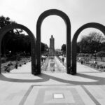 Monochrome image of Buddhist temple with statues and garden in Varanasi.