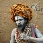 Portrait of a traditional sadhu with painted face and colorful turban in Varanasi, India.