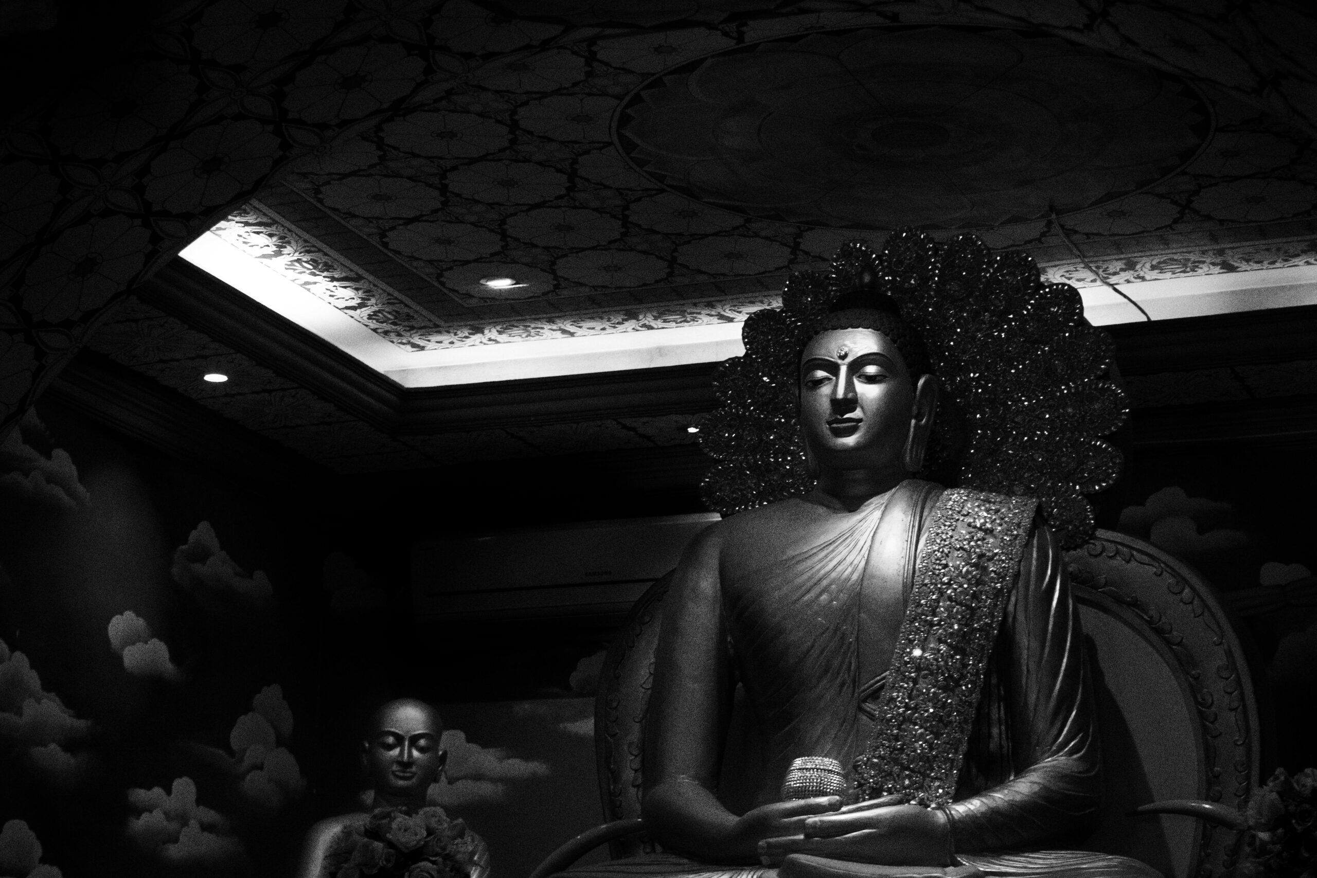 Striking black and white photo of a Buddha statue in Bodh Gaya, India, showcasing calmness and spirituality.